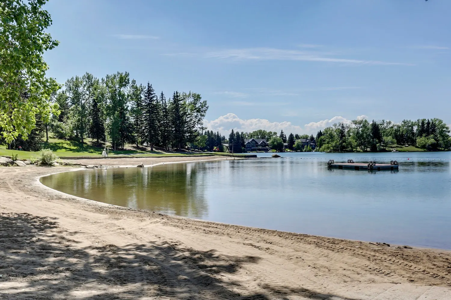 Sandy beach and swim dock on Lake Bonavista on a summer day